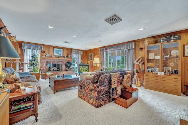 carpeted living room featuring wooden walls, crown molding, and a brick fireplace