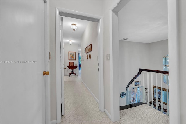 corridor featuring light colored carpet