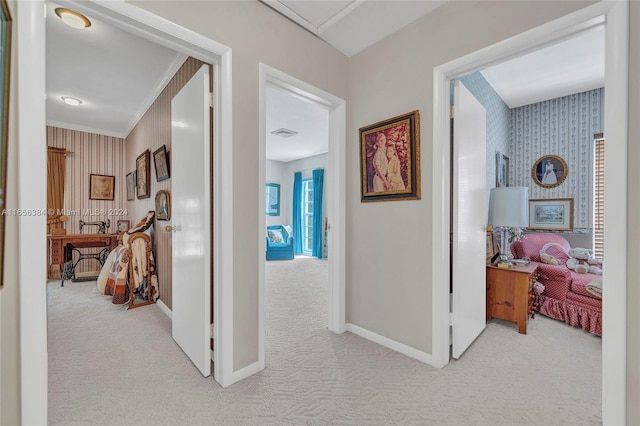 corridor featuring ornamental molding and light colored carpet