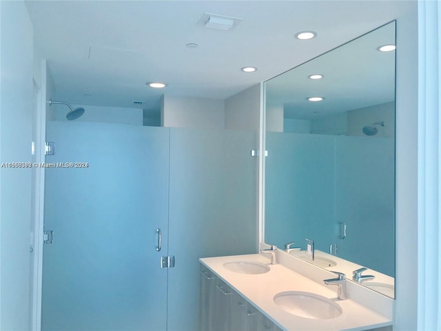 bathroom with recessed lighting, a stall shower, and a sink