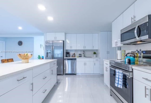 kitchen featuring stainless steel appliances, sink, light tile patterned floors, and white cabinets