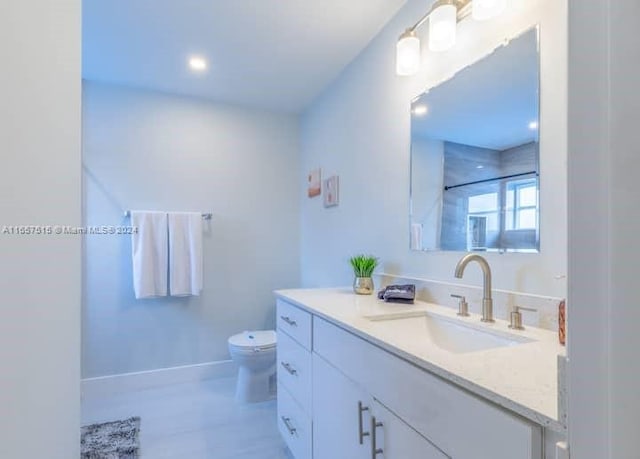 bathroom with vanity, toilet, and a shower