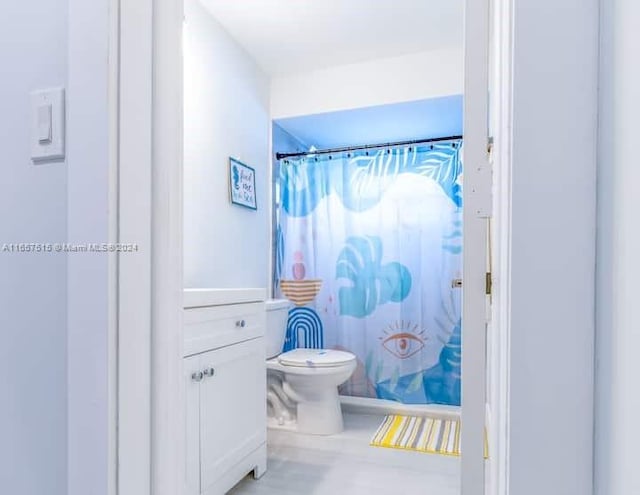 bathroom with vanity, toilet, and curtained shower