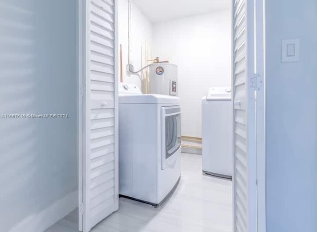 clothes washing area featuring separate washer and dryer and water heater