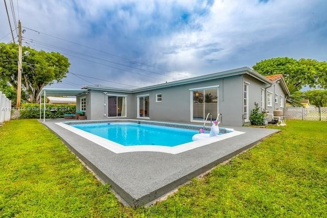 view of swimming pool featuring a lawn and a patio area