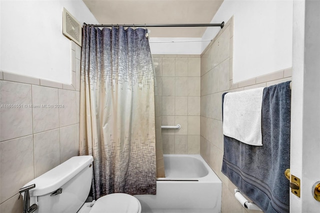 bathroom with shower / bath combo, toilet, and tile walls