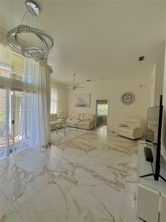 unfurnished living room featuring a textured ceiling and ceiling fan