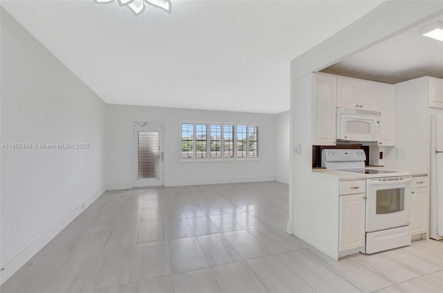 kitchen with white appliances, white cabinets, and a textured ceiling