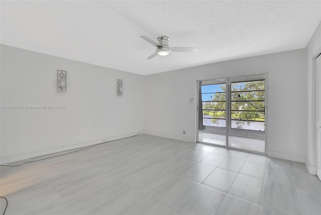 tiled empty room with ceiling fan and a textured ceiling