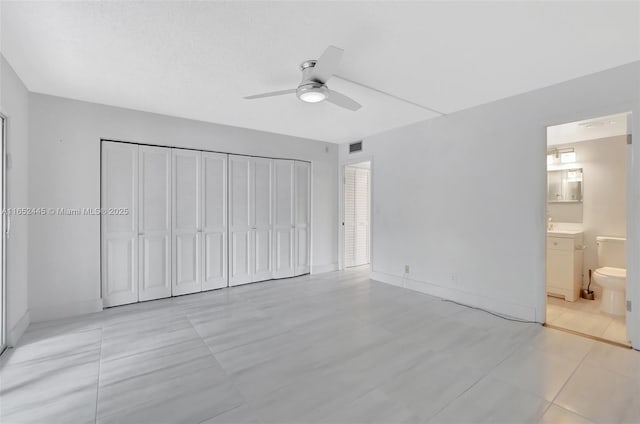 unfurnished bedroom with ensuite bath, sink, a closet, ceiling fan, and light tile patterned floors