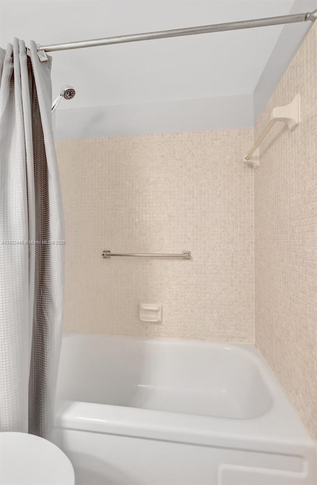 bathroom featuring toilet and shower / tub combo with curtain