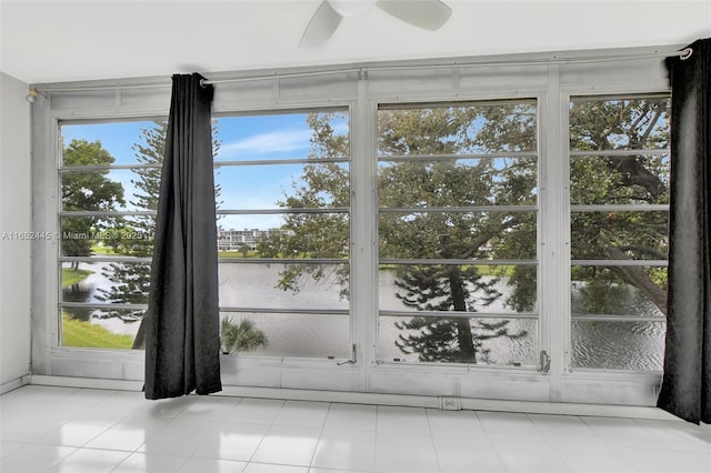 unfurnished sunroom featuring ceiling fan and plenty of natural light