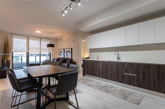 dining area featuring light wood-type flooring, french doors, and sink