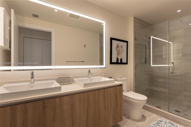 bathroom featuring vanity, toilet, hardwood / wood-style flooring, and a shower with door