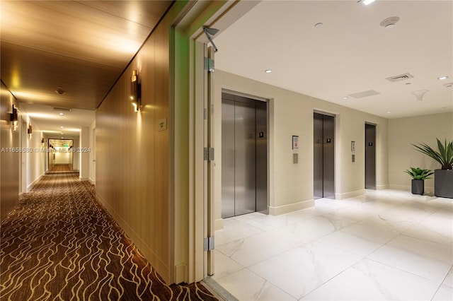 hall featuring elevator and wooden walls