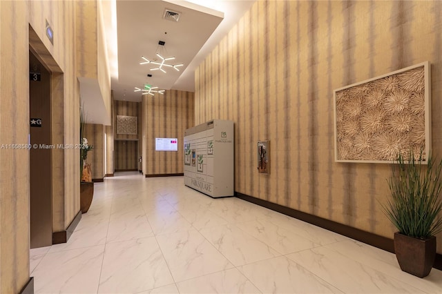 hallway with an inviting chandelier and a towering ceiling