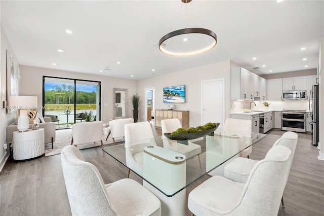 dining space featuring sink and light hardwood / wood-style floors