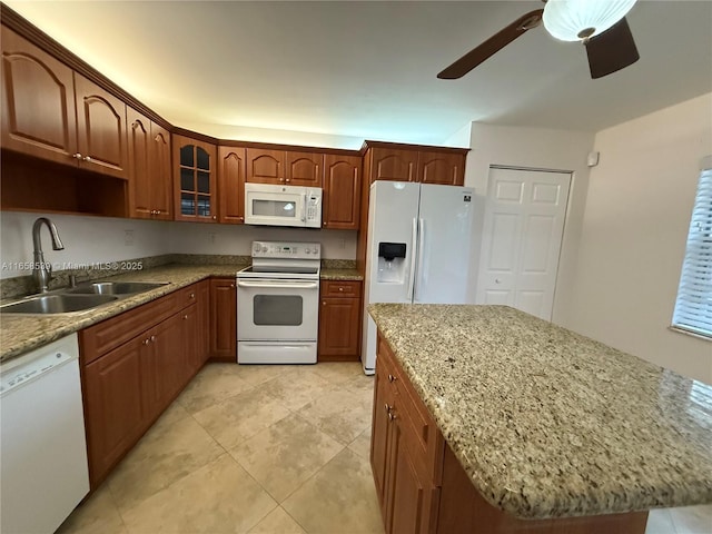 kitchen with ceiling fan, sink, light stone countertops, and white appliances