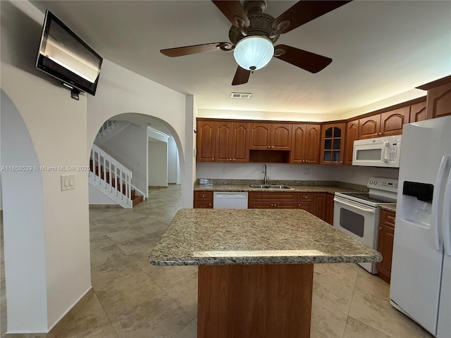 kitchen with ceiling fan, a center island, white appliances, and sink