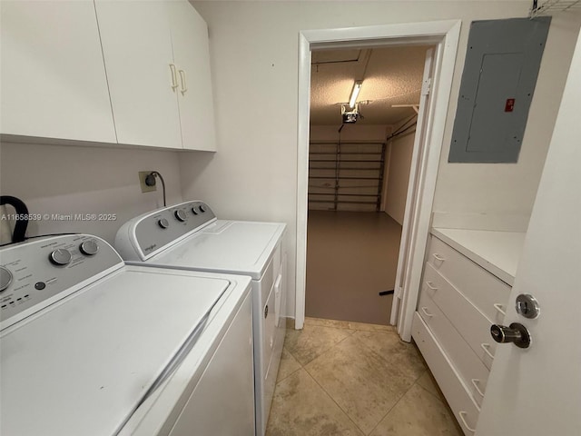 laundry room featuring washer and clothes dryer, cabinets, light tile patterned floors, and electric panel