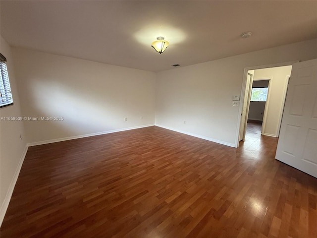 empty room with dark hardwood / wood-style flooring