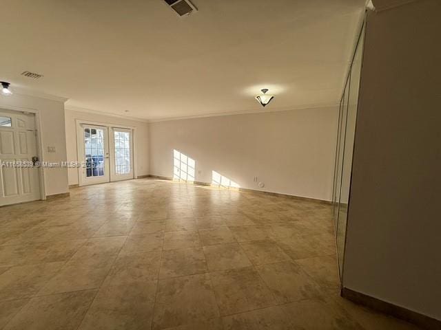 empty room featuring crown molding and french doors