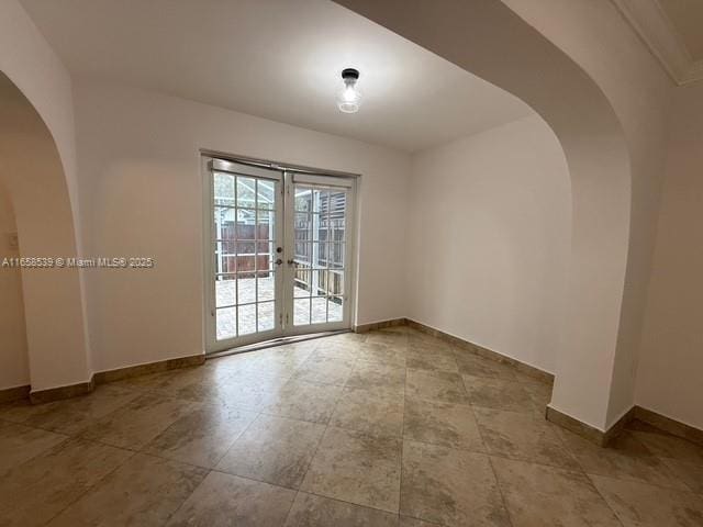 unfurnished room featuring french doors