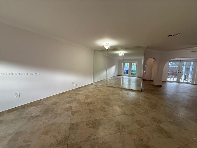 empty room with ceiling fan, french doors, and ornamental molding