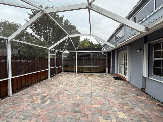 view of patio with glass enclosure and french doors