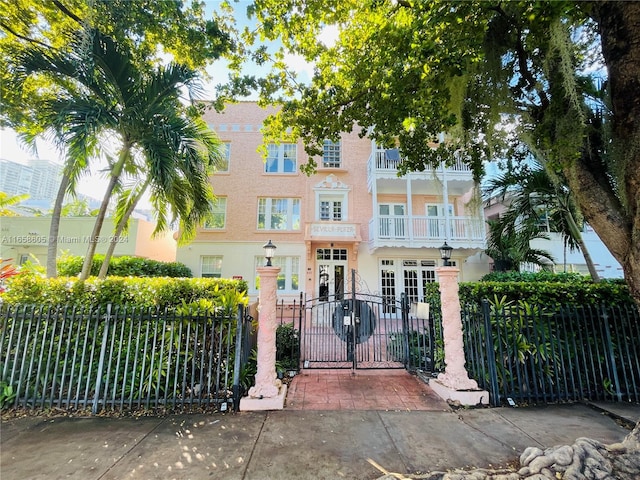 view of front of house with a balcony and french doors