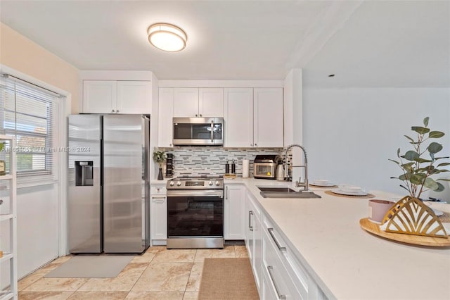 kitchen featuring stainless steel appliances, sink, decorative backsplash, and white cabinetry