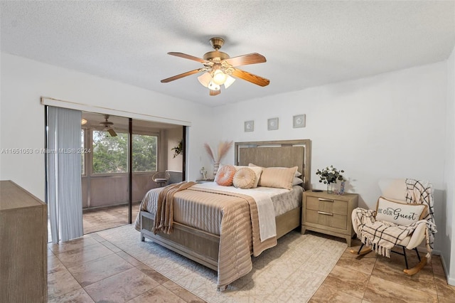 bedroom featuring a textured ceiling, access to exterior, and ceiling fan