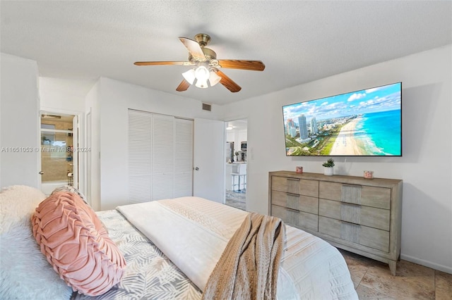 bedroom with a textured ceiling, ceiling fan, a closet, and connected bathroom