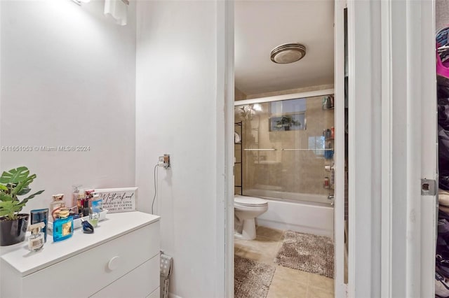 full bathroom featuring vanity, toilet, tile patterned floors, and bath / shower combo with glass door