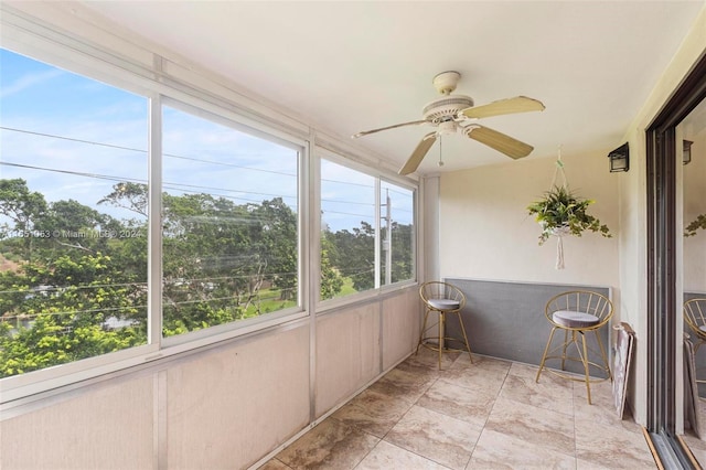 sunroom featuring ceiling fan