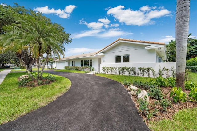 ranch-style home featuring a front yard and a garage