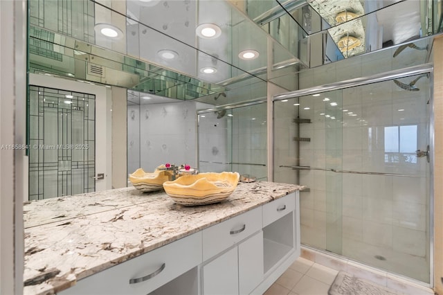 bathroom with an enclosed shower, vanity, and tile patterned floors