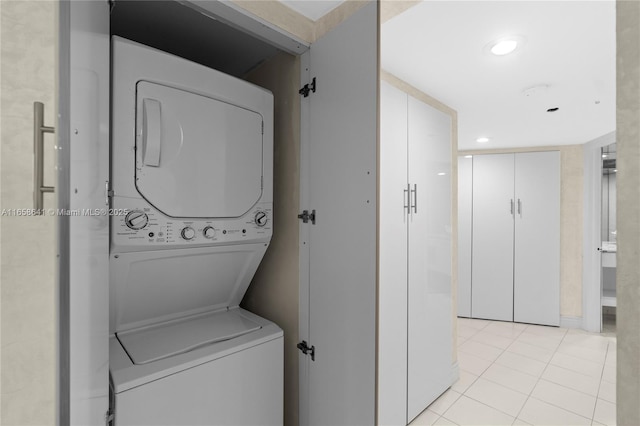 clothes washing area with stacked washer and dryer and light tile patterned floors