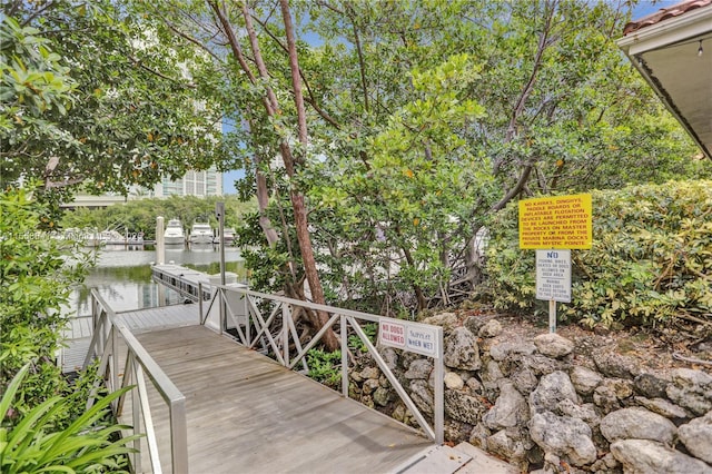 surrounding community featuring a water view and a boat dock