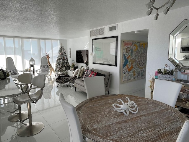 dining space featuring a textured ceiling and light tile patterned floors