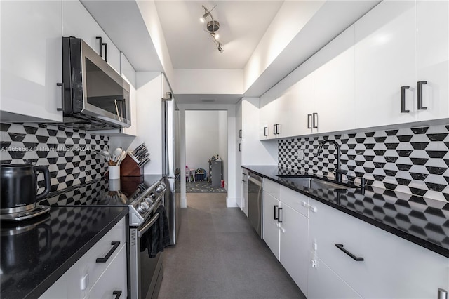 kitchen with appliances with stainless steel finishes, decorative backsplash, sink, and white cabinets