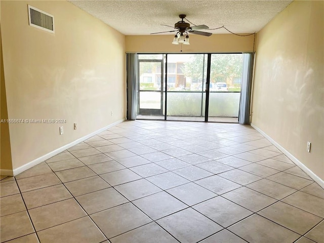 tiled spare room with ceiling fan and a textured ceiling