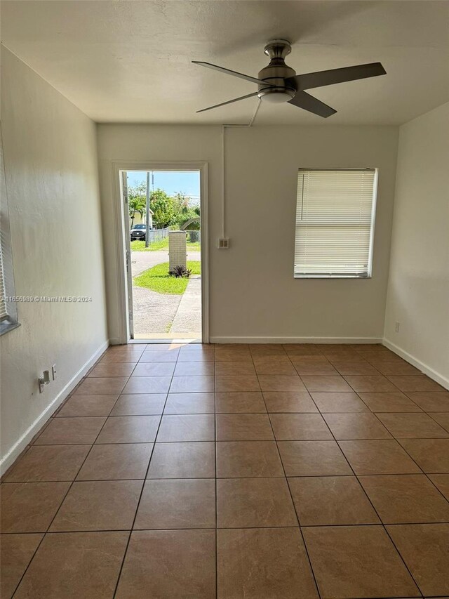 tiled spare room featuring ceiling fan