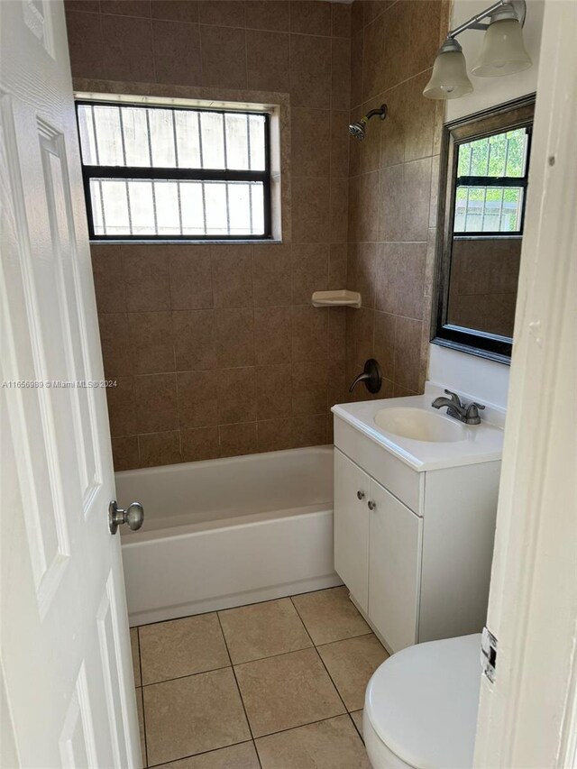 full bathroom with tiled shower / bath, vanity, tile patterned flooring, and toilet