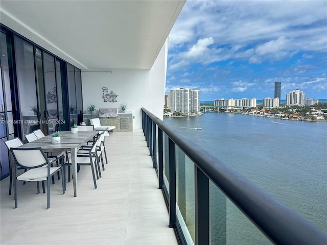 balcony with a view of city, cooling unit, and a water view