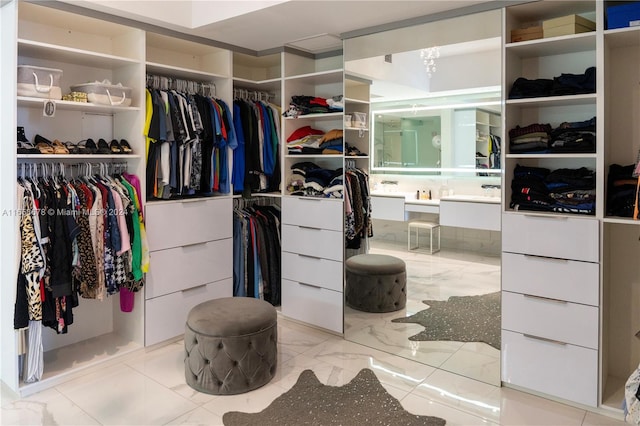 walk in closet featuring marble finish floor