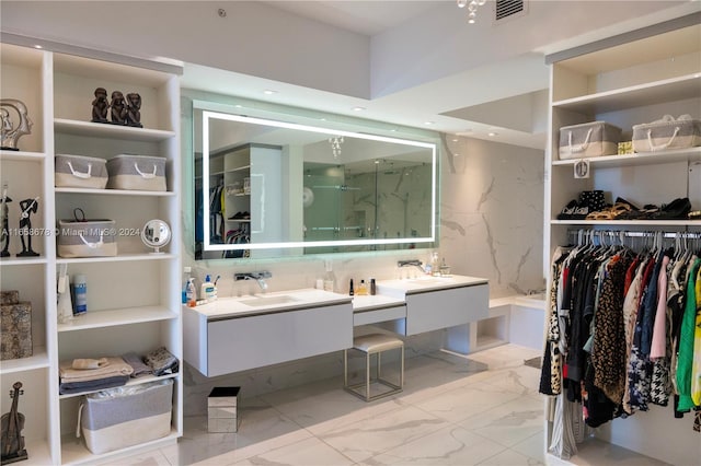 bathroom with visible vents, marble finish floor, a walk in closet, and vanity