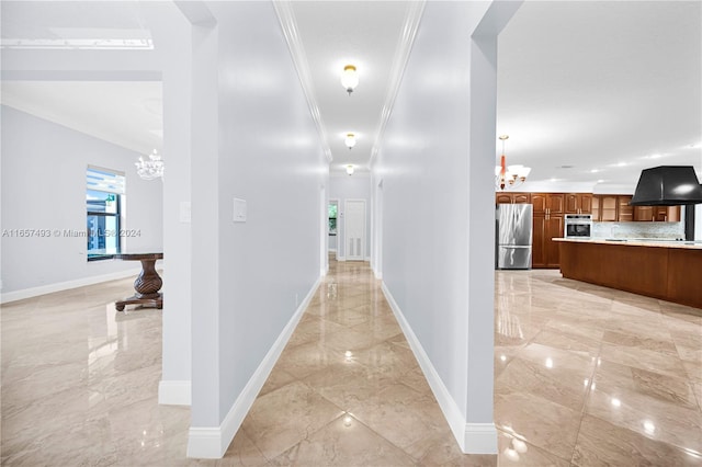 corridor with marble finish floor, an inviting chandelier, and baseboards