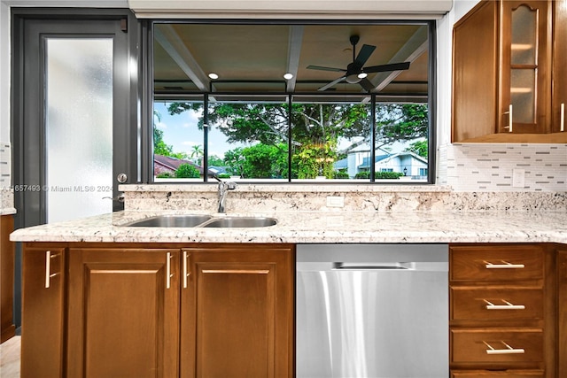 kitchen featuring dishwasher, brown cabinetry, ceiling fan, and a sink