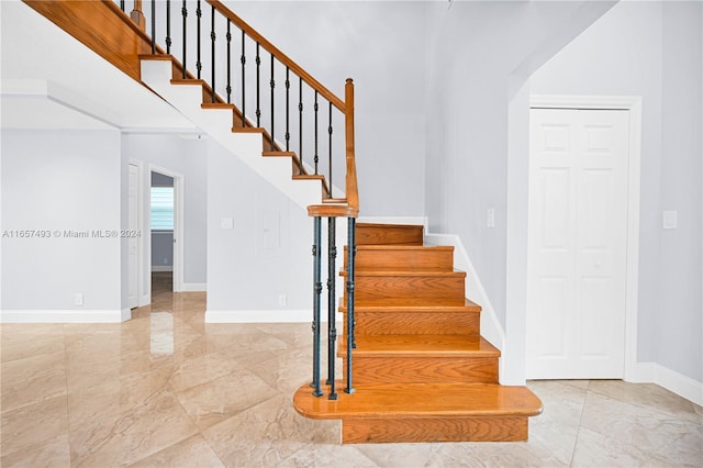 stairway with baseboards and marble finish floor